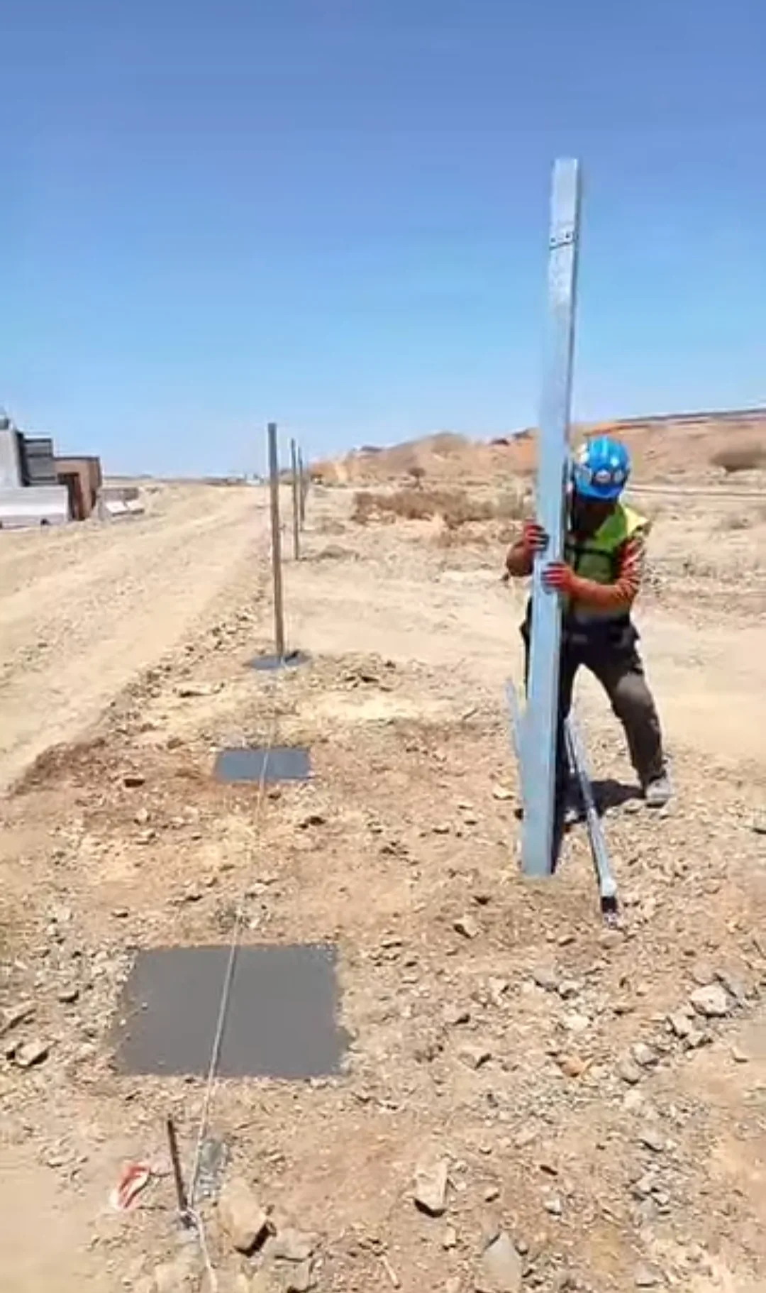 Galvanized post being set on a concrete base with a guide string