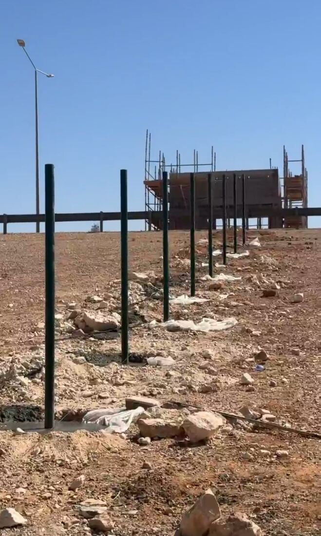أعمدة سياج شبكي قيد التركيب حول أرض في السعودية